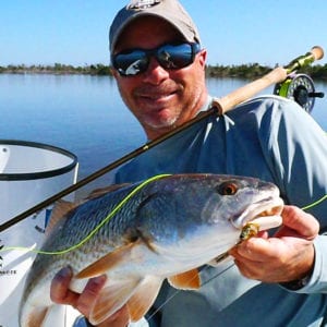 Angler holding a redfish caught on fly rod in Boca Grande. Florida
