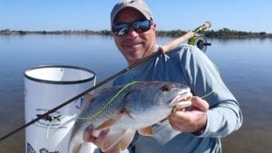 Angler holding a redfish caught on fly rod in Boca Grande. Florida